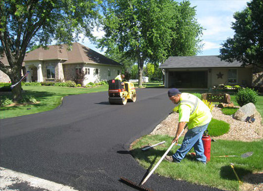 Two men finishing paving a driveway